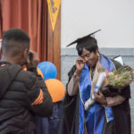 Graduate holding flowers and wiping tears