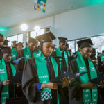 Group of graduates reciting from paper