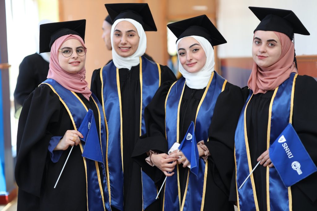 Four female GEM students donning their cap and gowns